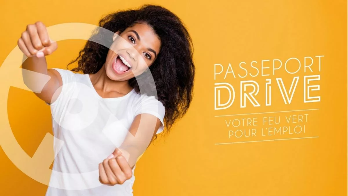 Une femme tenant un volant en l'air pour illustrer l'idée d'apprendre à conduire gratuitement grâce au Passeport Drive 2024.