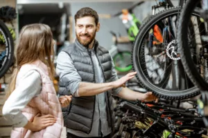 Une femme regarde des vélos pour décider lequel acheter grâce aux aides pour l'achat d'un vélo en Belgique.