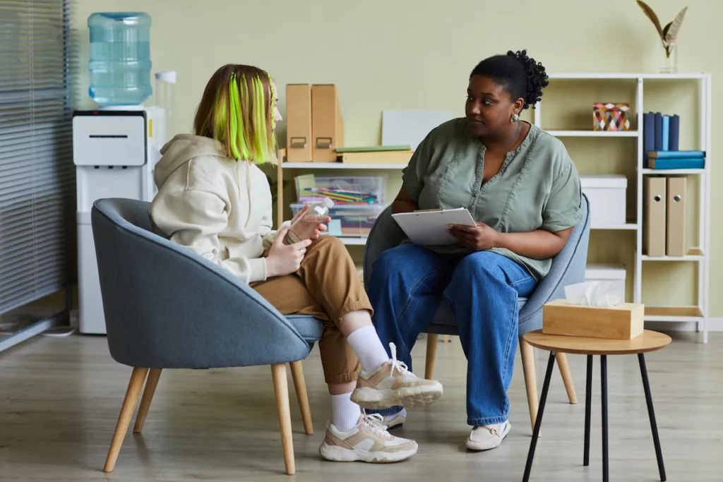 Image qui montre une assistante sociale en rendez-vous avec une jeune fille, suite à une demande d’aide au CPAS