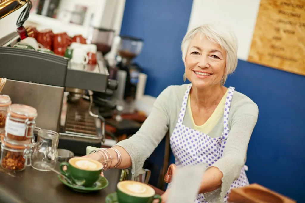 Une femme souriante servant des cafés dans un bar, représentant les opportunités offertes par les flexi-jobs en Belgique pour combiner emploi et flexibilité