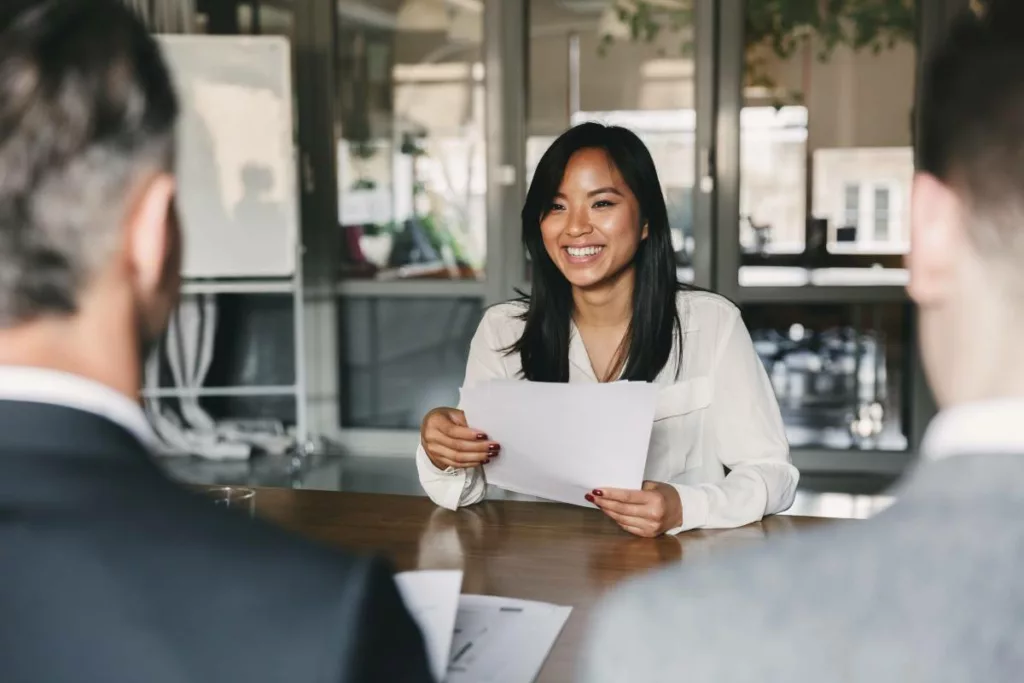 Une femme souriante en entretien professionnel, illustrant le dispositif belge Impulsion 12 mois + pour favoriser le retour à l’emploi.