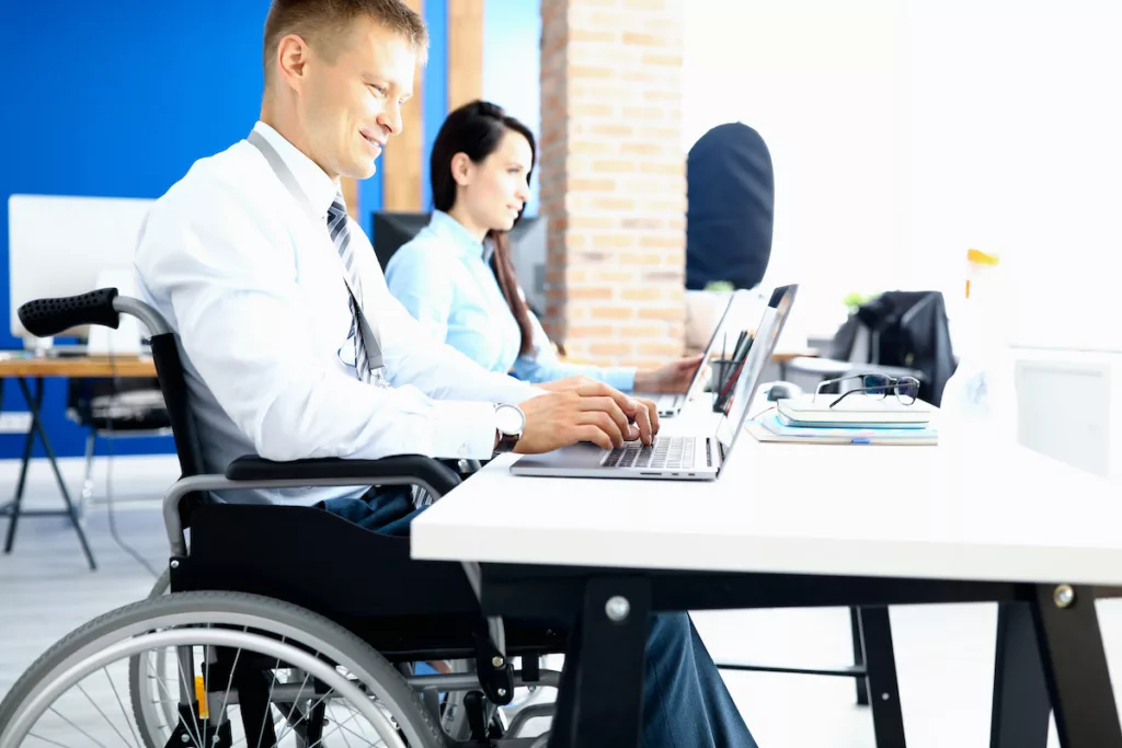 Image d’un employé en situation de handicap qui bénéficie de matériel de bureau spécifique grâce à la prime handicap