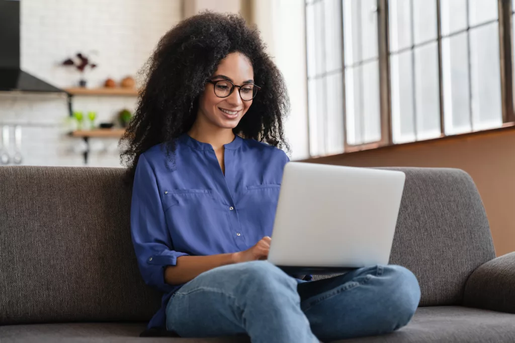 image d'une jeune femme sur son ordinateur pour illustrer la facilité de demander votre certificat de composition de ménage en ligne