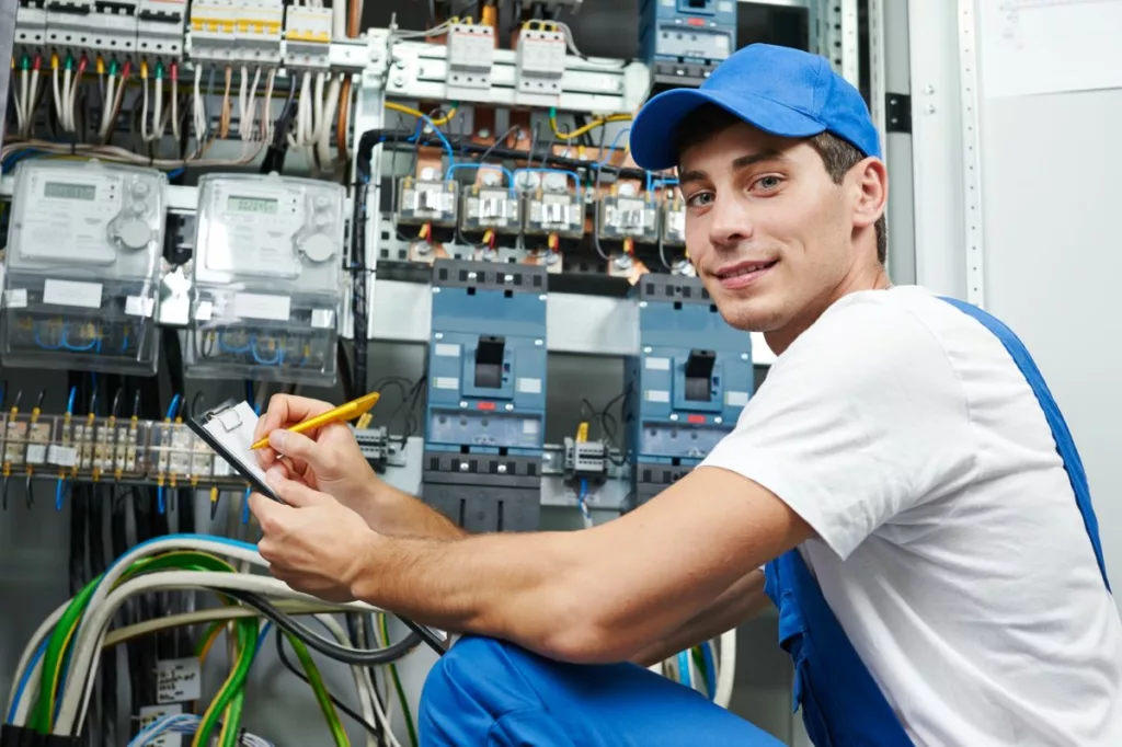 Un électricien inspectant un tableau électrique, illustrant les travaux éligibles à la prime pour la mise en conformité de votre installation électrique en Belgique.