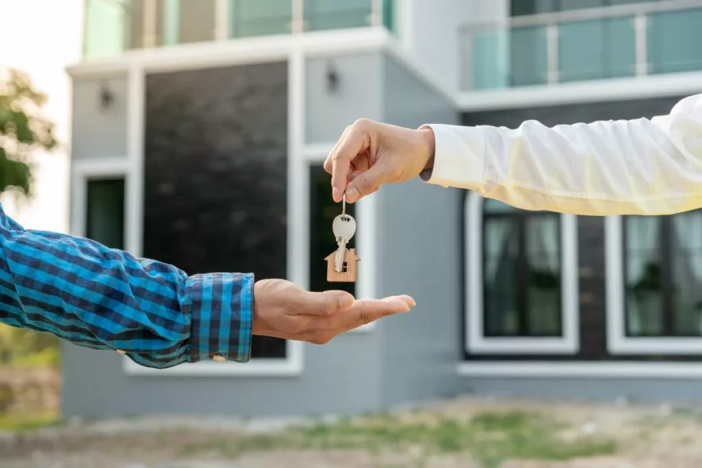 Remise des clés d'une maison à un nouveau locataire, illustrant le processus de signature d'un contrat de bail en Belgique.