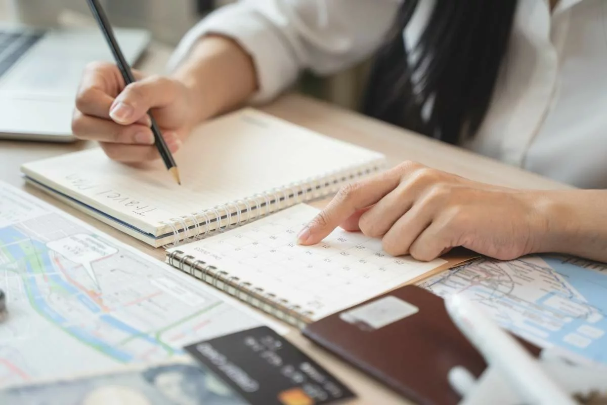 Planification des congés à l’aide d’un calendrier et de documents de voyage, illustrant le concept de Pécule de vacances.