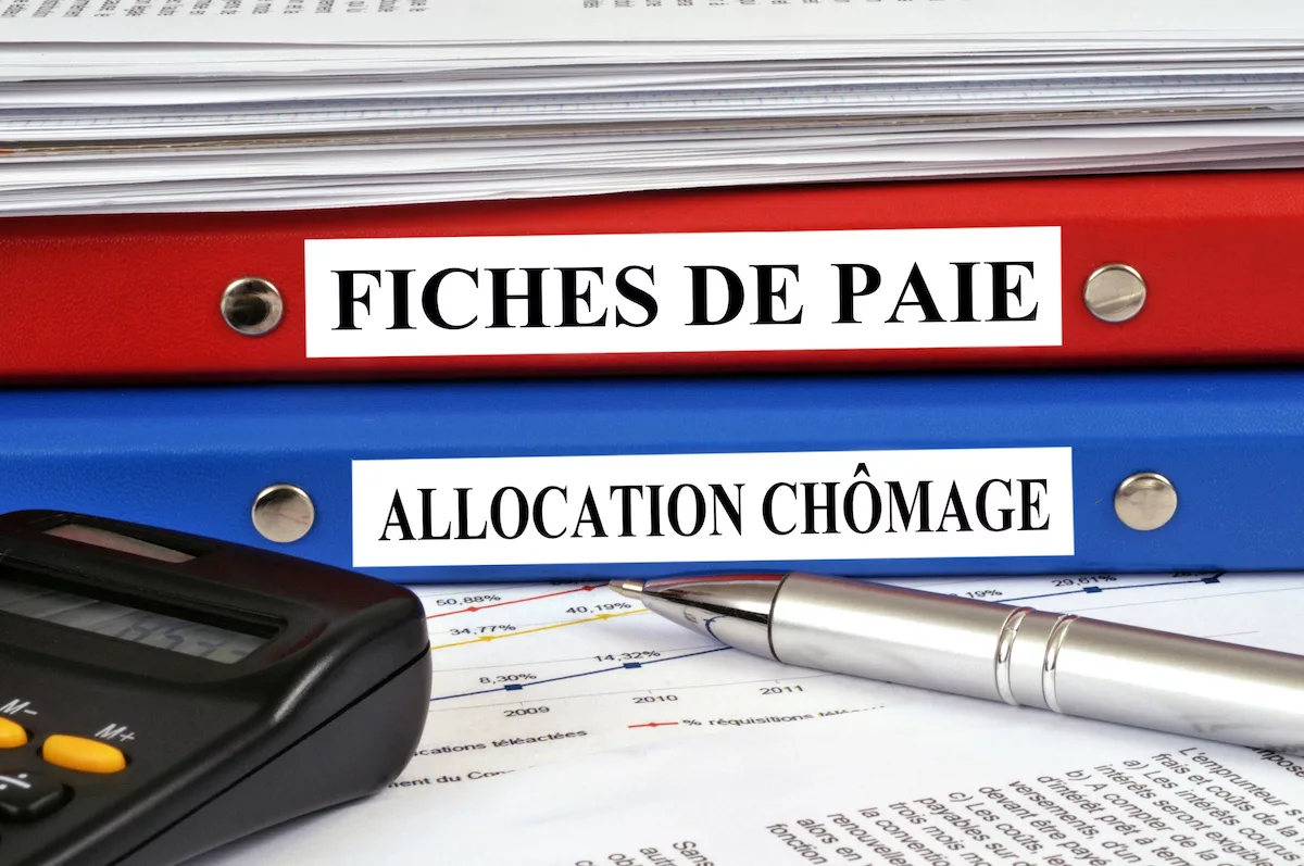 Image où figurent des dossiers d'allocations chômage, de fiches de paie, certains sujets concernés par l'accord Arizona.