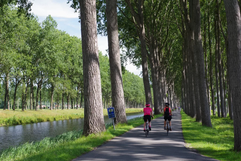 Un couple faisant du vélo tourisme, une bonne idée d’escapade si vous optimisez les congés en 2025.