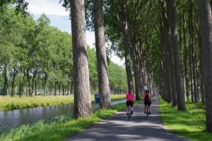 Un couple faisant du vélo tourisme, une bonne idée d’escapade si vous optimisez les congés en 2025.