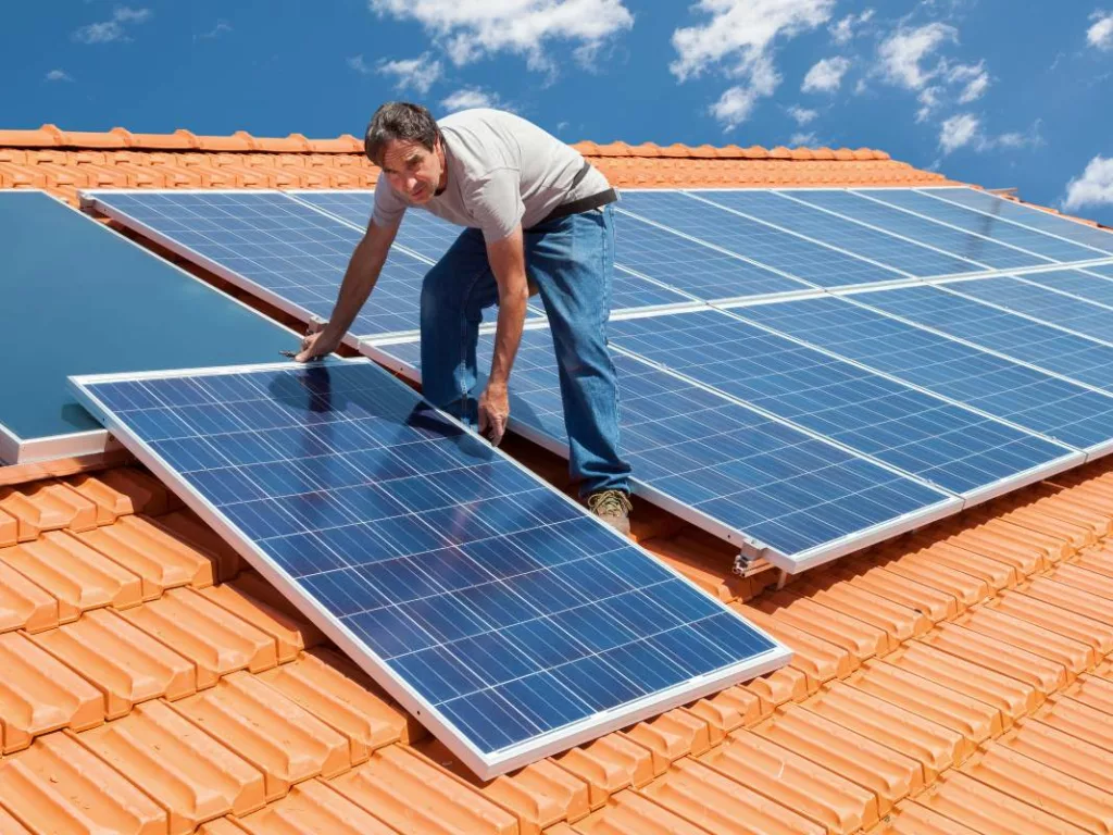 Un homme installer des panneaux solaires pour lesquels s'applique le tarif prosumer 2025.