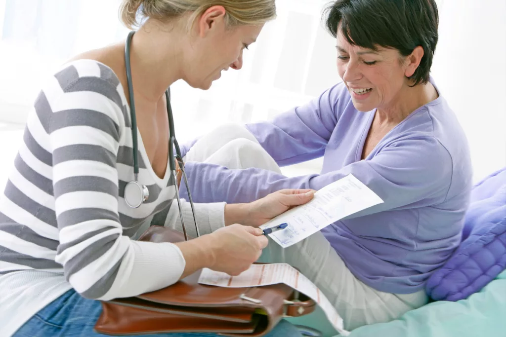 Image montrant la visite d’un médecin à domicile, un des soins couverts par la Mutualité chrétienne