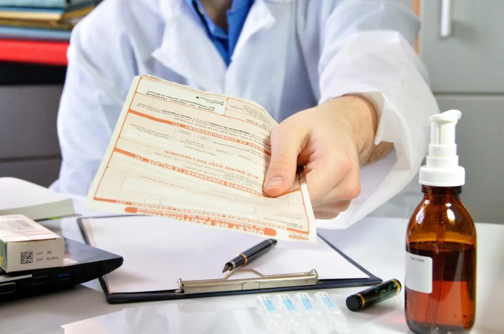 Un médecin remet au patient la feuille de soin pour demander le remboursement à la mutualité neutre.