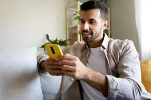 Un chômeur consultant la date de paiement de son allocation sur FGTB depuis son téléphone.