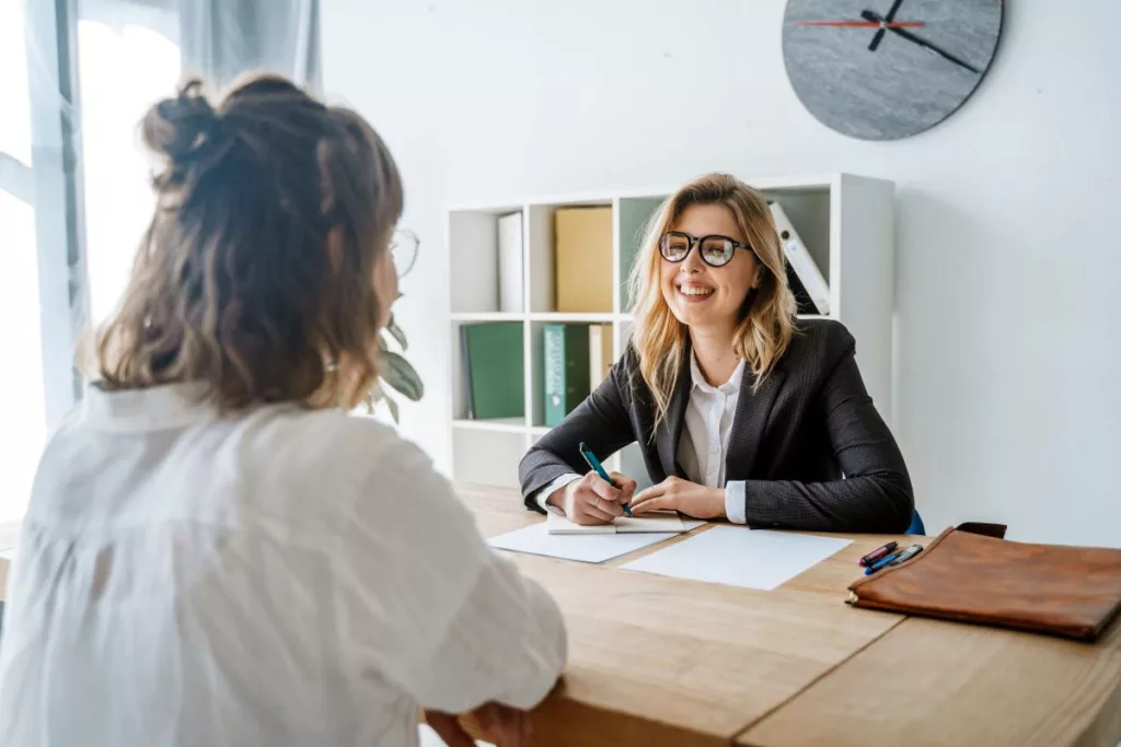 Une jeune en tant que demandeur d’emploi libre en réunion d’orientation avec une conseillère.