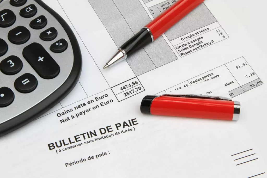 Un salarié vérifie sur sa fiche de paie le calcul du précompte professionnel retenu par l’employeur.