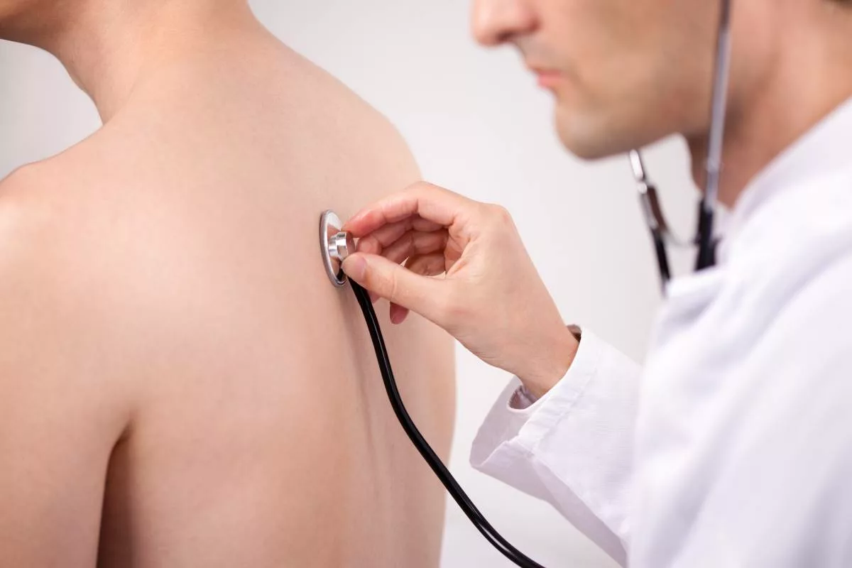 Un médecin-contrôleur examine un travailleur malade, chez lui, après dépôt d’un certificat médical.