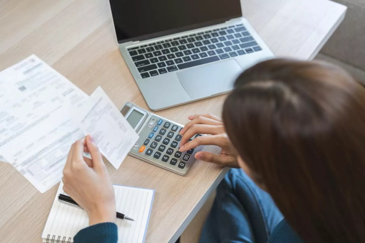 Une salariée vérifie son salaire garanti à l’aide de ses fiches de paie, lors de son arrêt maladie.