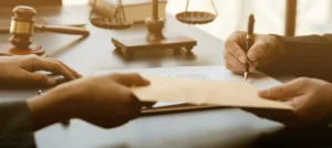 Un héritier signe chez le notaire pour bénéficier de l’héritage et la succession de son père décédé.